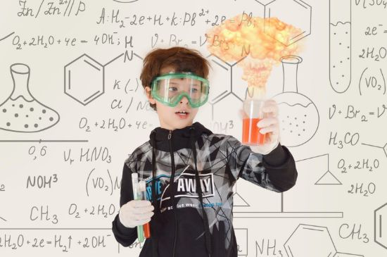 Boy wearing safety goggles doing chemical expirament