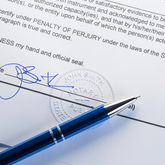 Close-up of a signed document with a blue pen resting on it and an embossed notary seal visible near the signature line.
