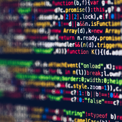 Close-up of colorful programming code displayed on a computer screen, with lines of text in various colors such as green, red, yellow, and white against a dark background, slightly blurred to emphasize the pattern of code rather than specific words.